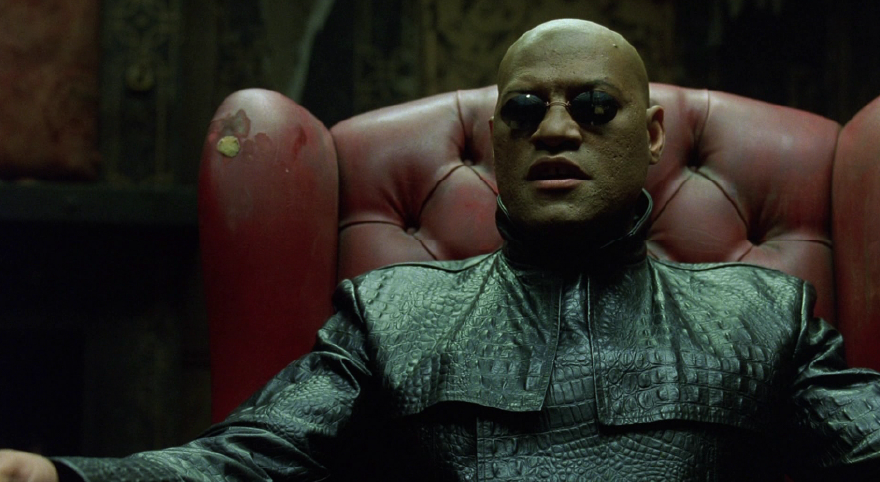 Morpheus, from the movie The Matrix (1999), sitting in a couch